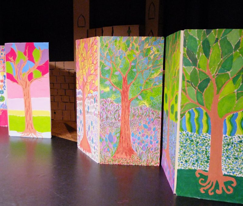 Décors de spectacle avec des arbres peints sur de grands panneaux