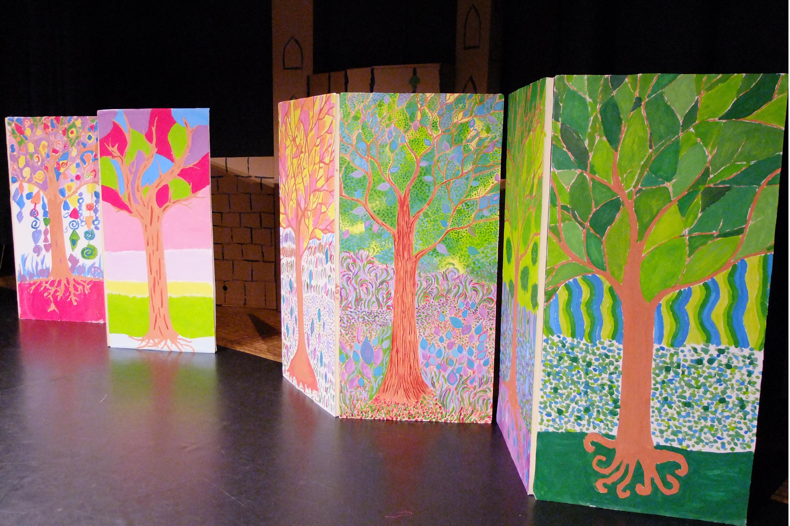 Décors de spectacle avec des arbres peints sur de grands panneaux
