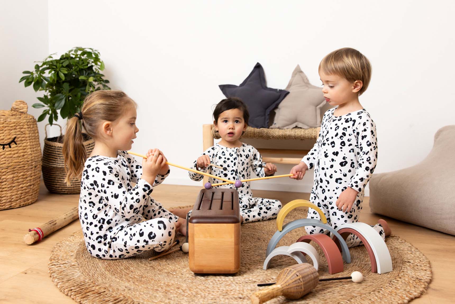 Trois très jeunes enfants autour d'une sorte de xylophone