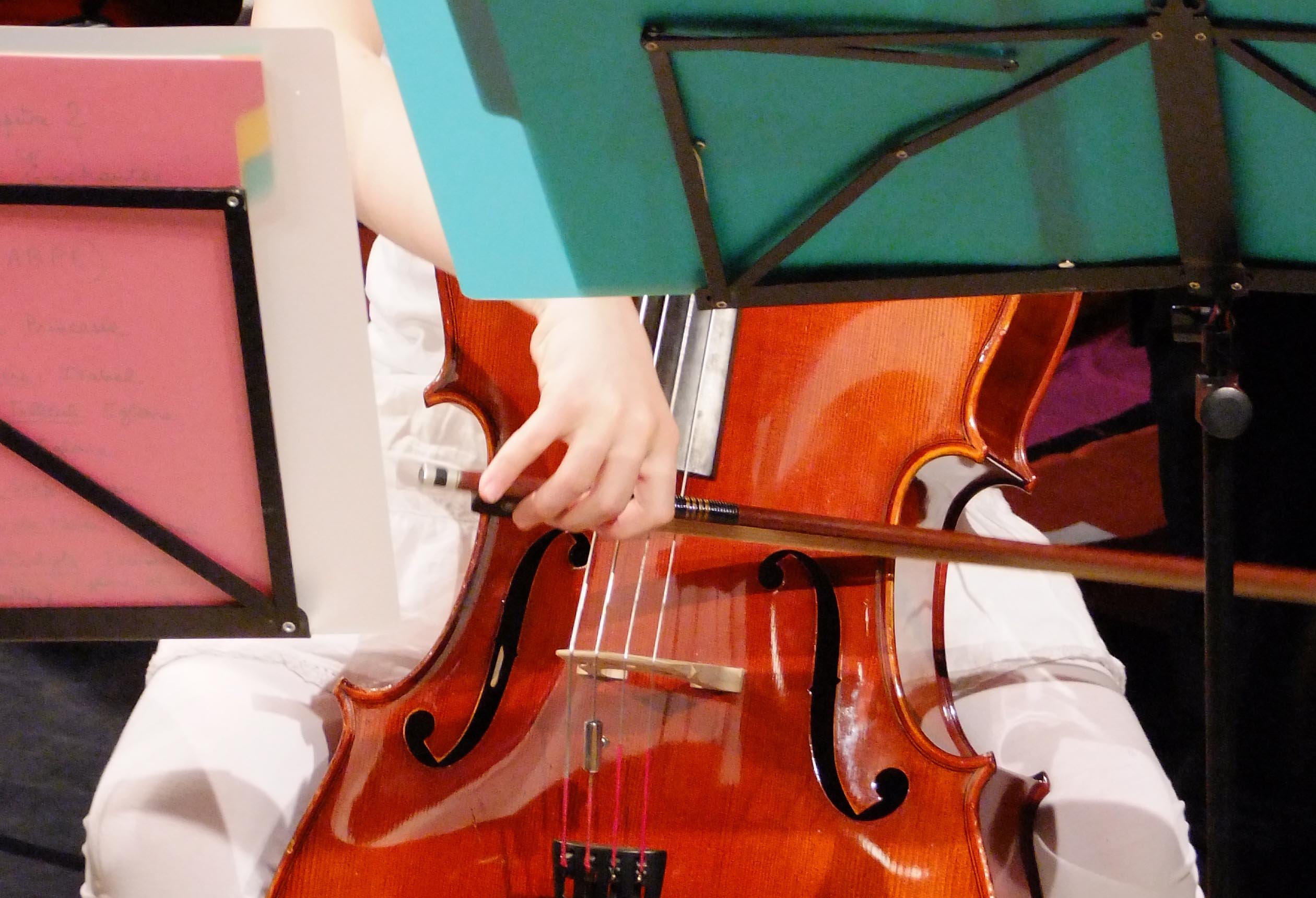 Photo d'un enfant jouant du violoncelle : gros plan sur le violoncelle et l'archet