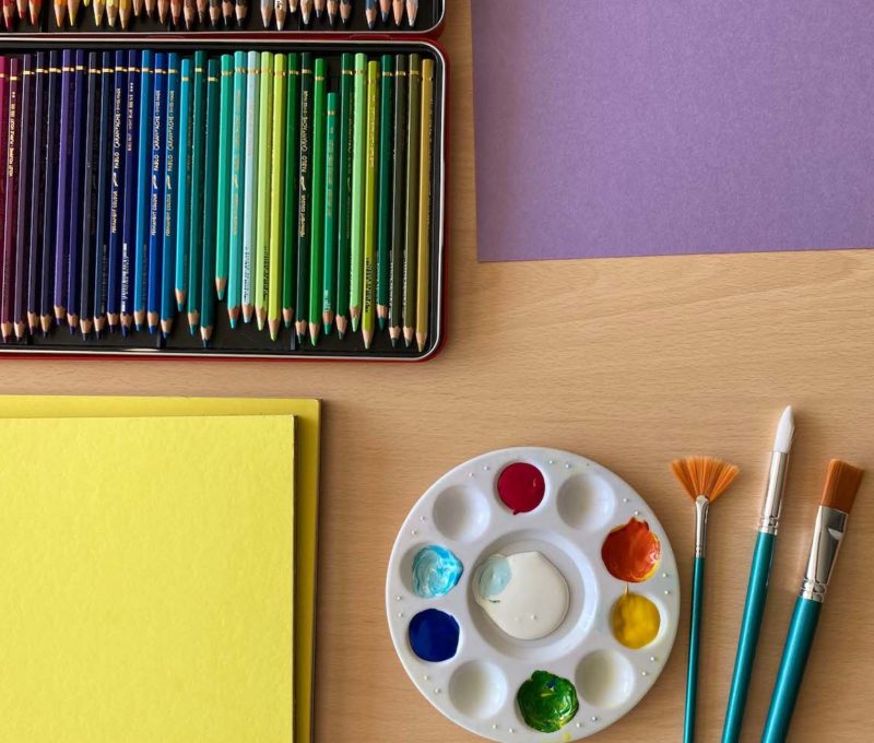 Crayons de couleur, palette, pinceaux, papier coloré