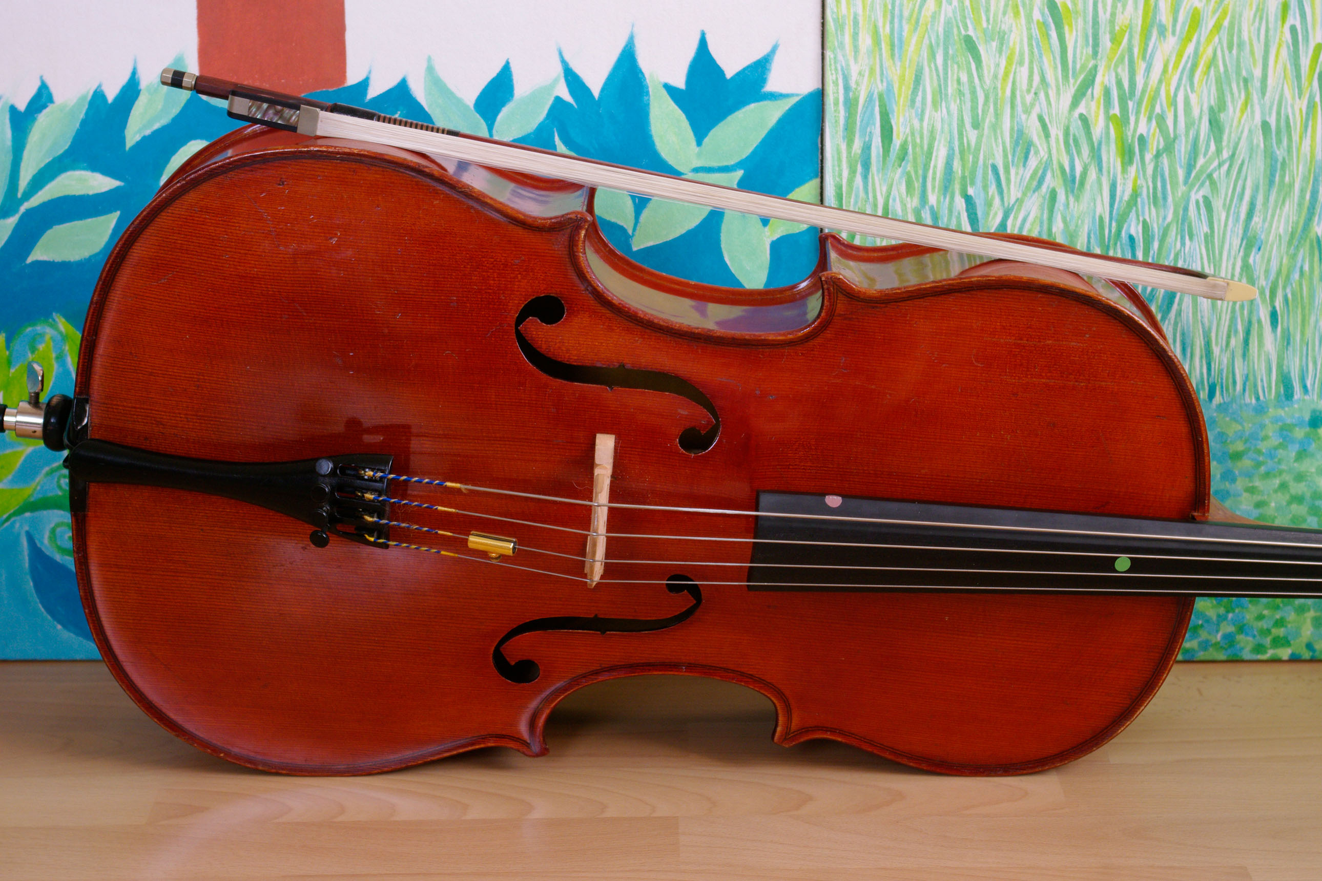 violoncelle d'enfant en gros plan, sur fond de dessin