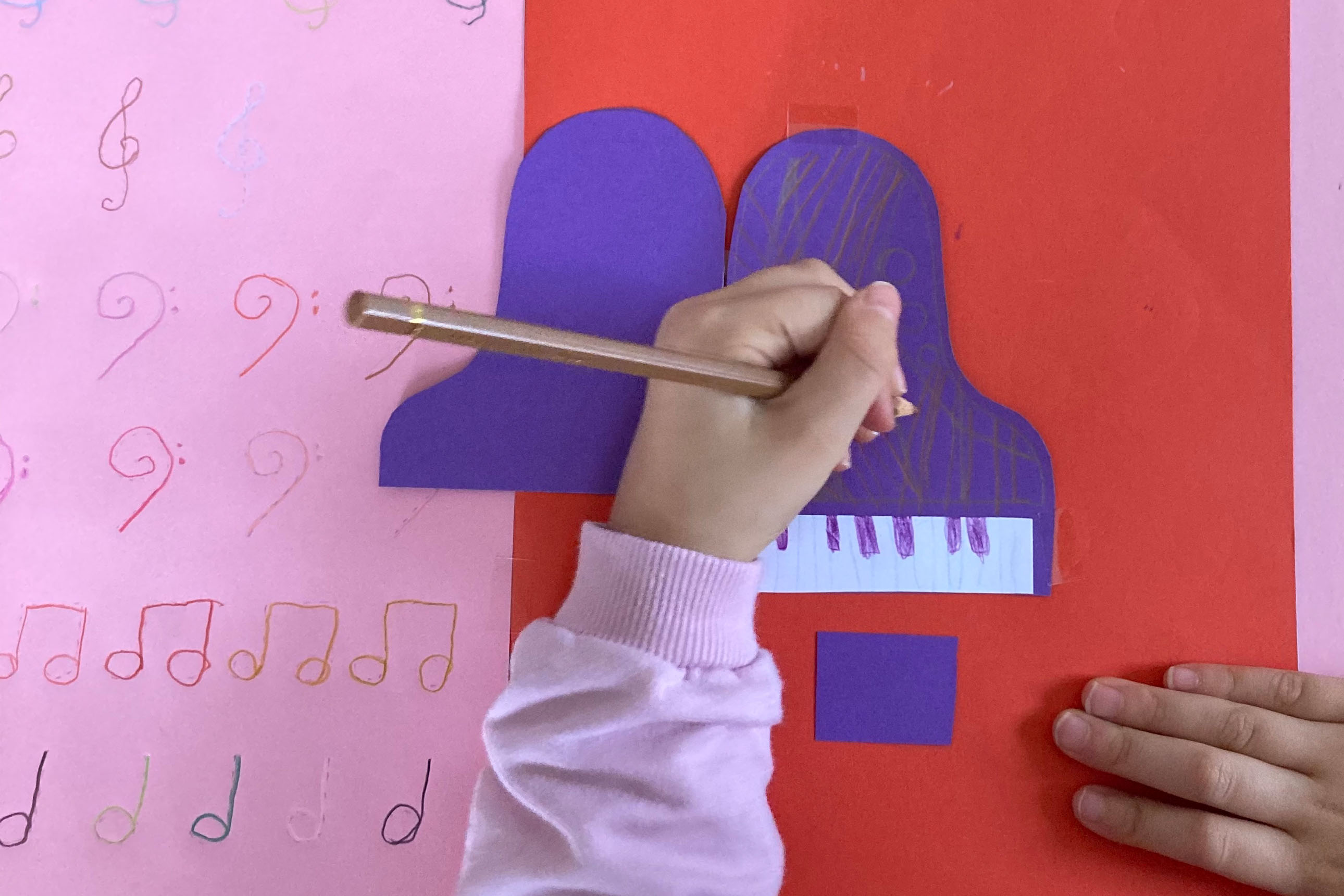 gros plan sur une main d'enfant coloriant un piano