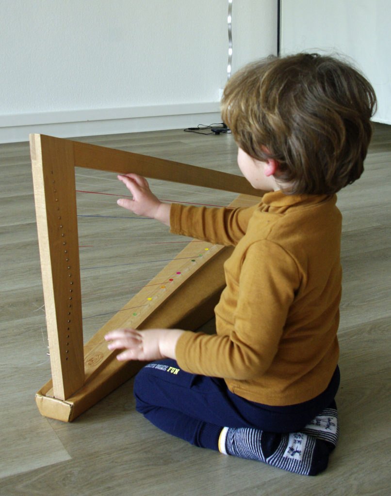 Enfant jouant d'une petite harpe