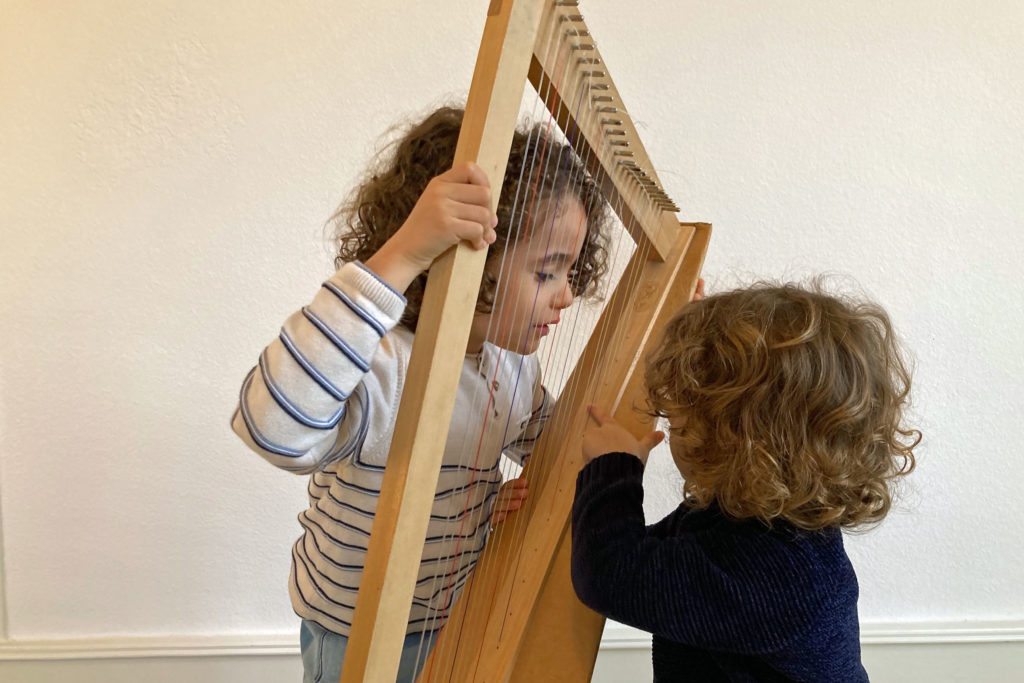 deux enfants autour d'une petite harpe