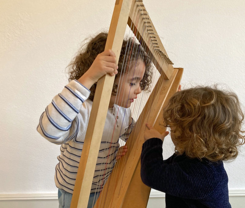 deux enfants autour d'une petite harpe