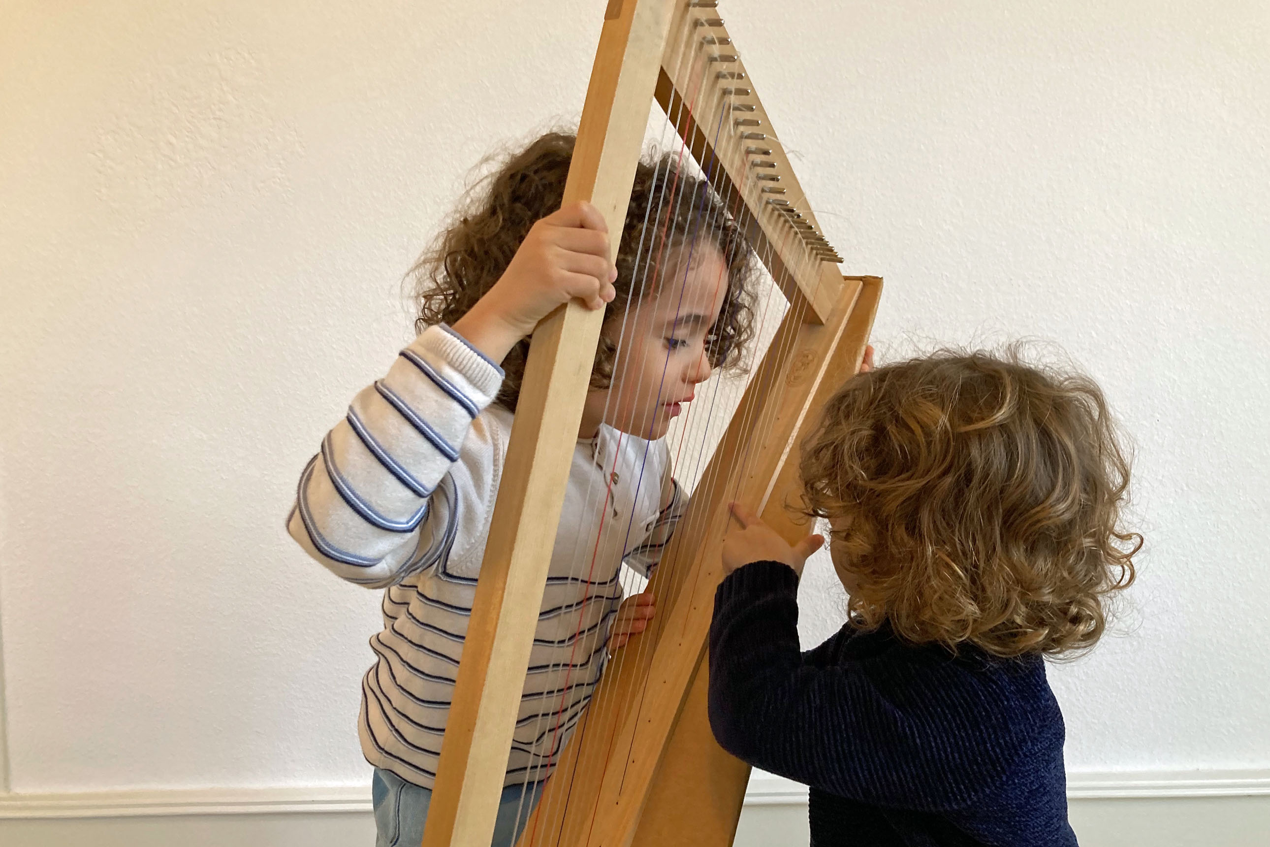 deux enfants autour d'une petite harpe