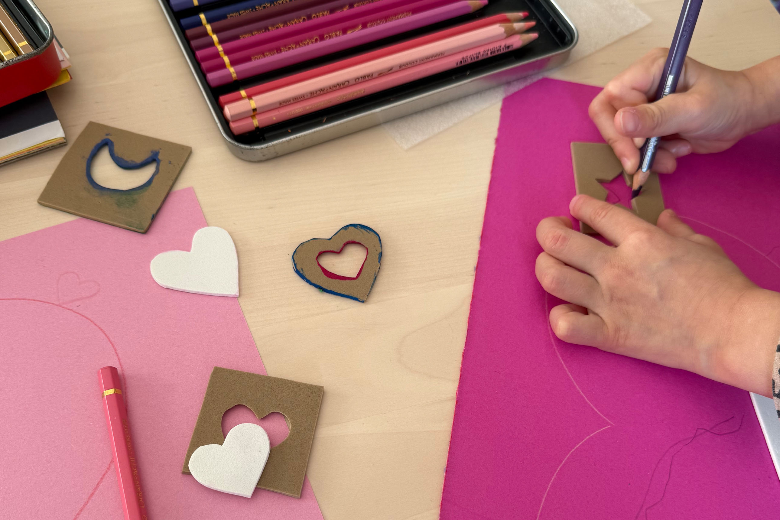 gros plan sur les mains d'un enfant qui dessine une étoile avec un pochoir