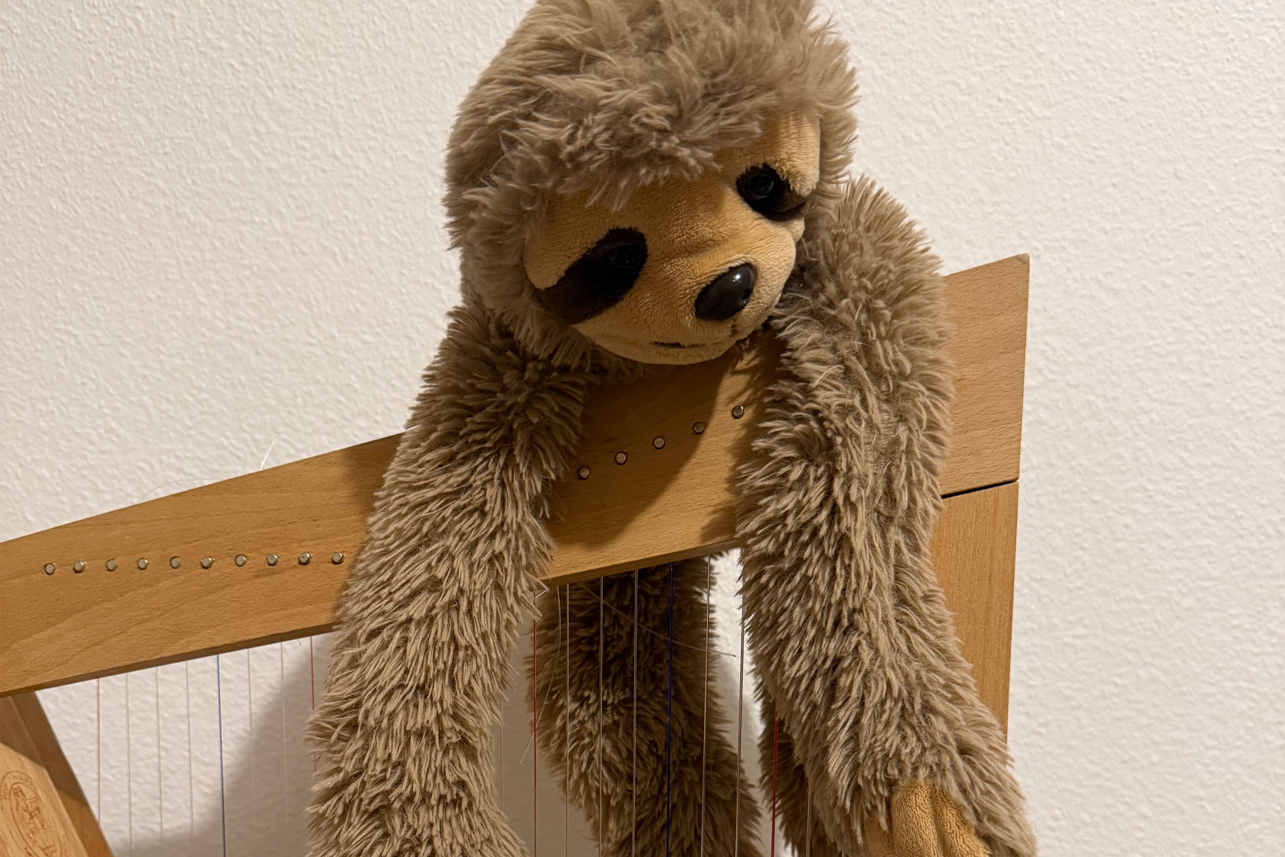 peluche de paresseux sur une petite harpe