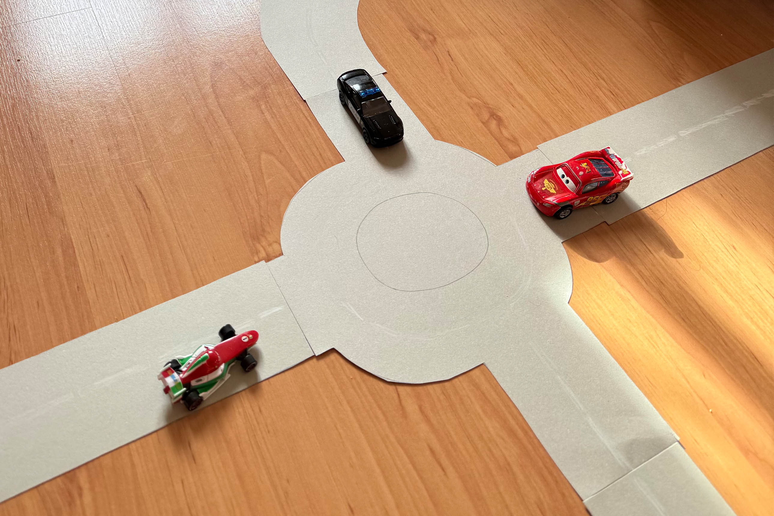 petites voitures sur un circuit en papier : rond point et route, marquage musical "court court long"