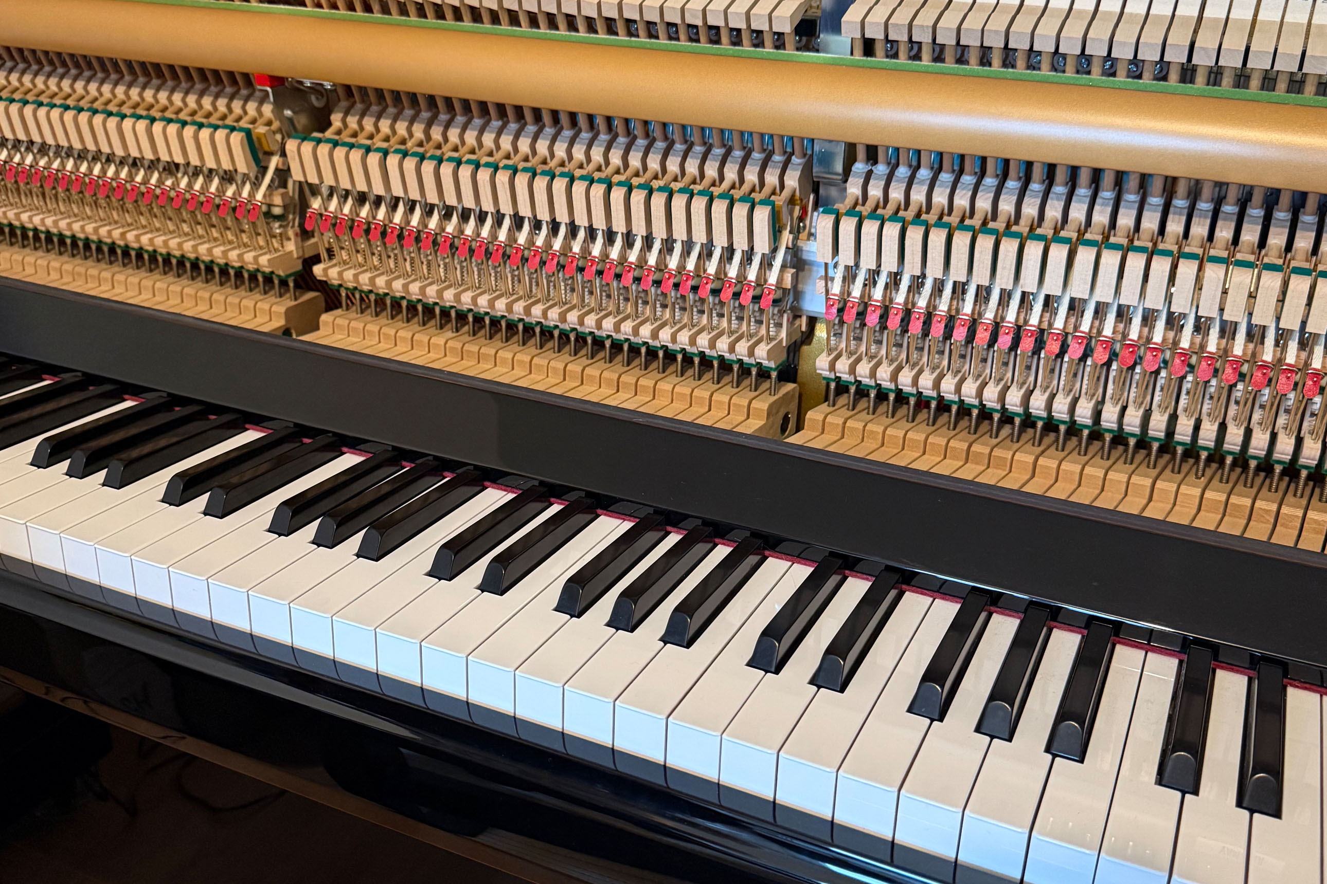 piano droit : une plaque est démontée si bien qu'on voit la mécanique à l'intérieur