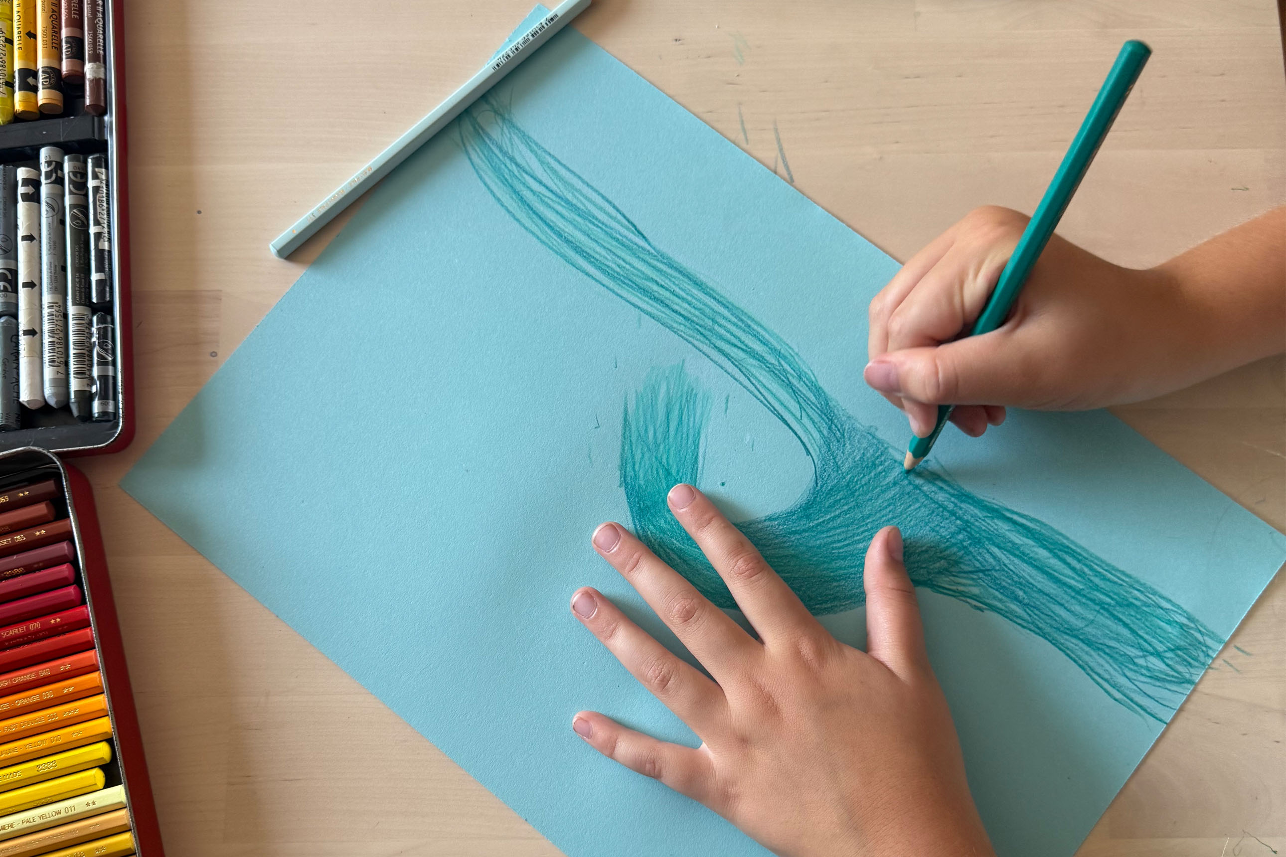 gros plan sur les mains d'un enfant dessinant une vague
