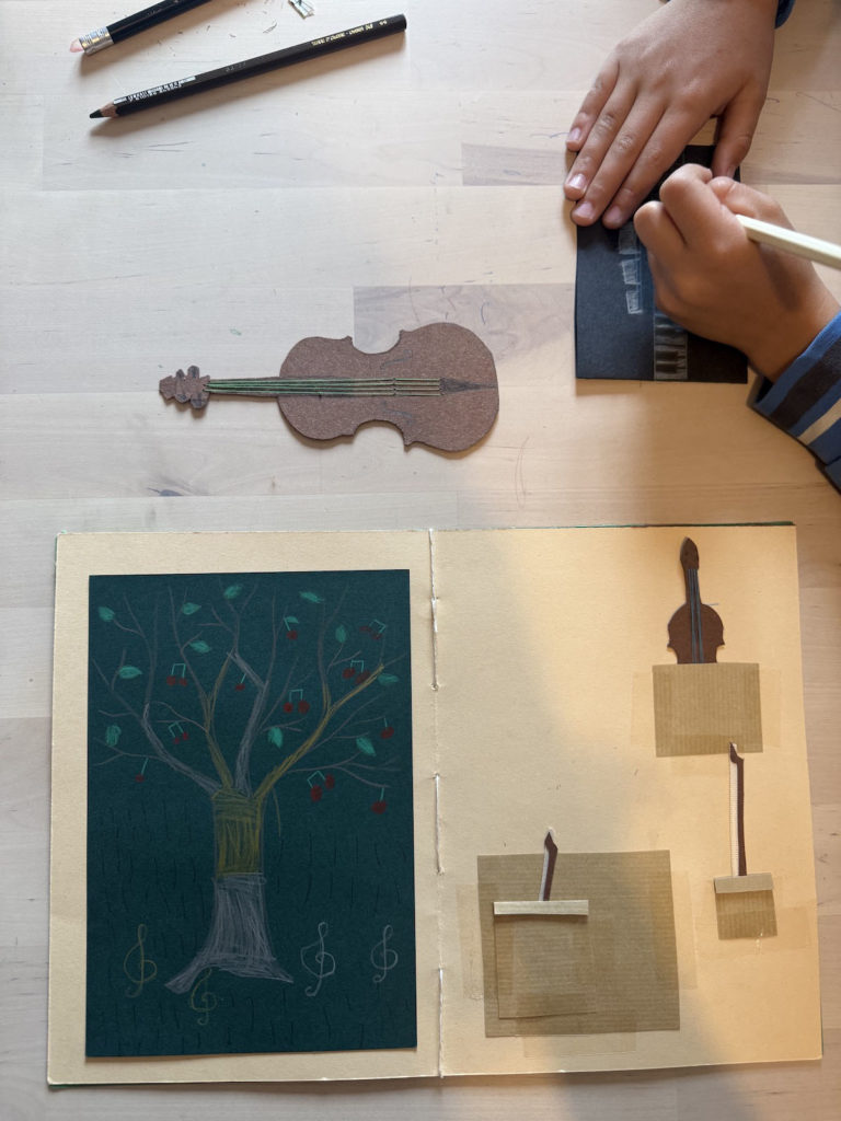 carnet de musique, mains d'enfant en train de dessiner un piano