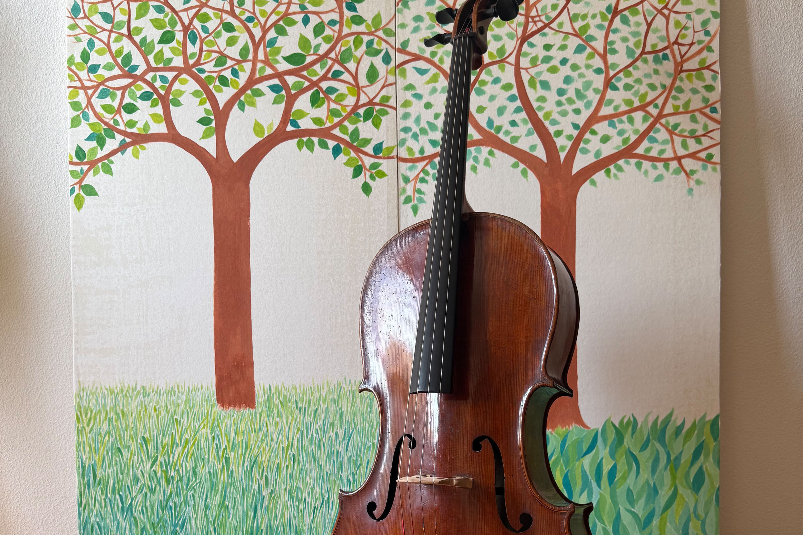 violoncelle devant un décor d'arbres en peinture