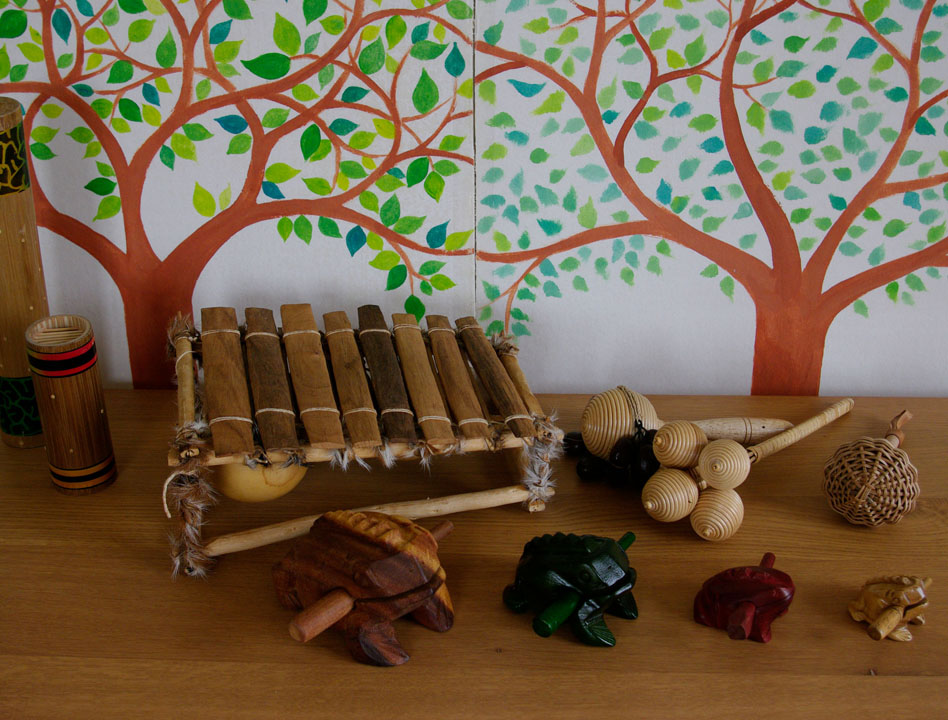 balafon, guis-grenouilles et maracasses, sur fond d'arbres peints